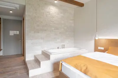 a bedroom with a bed and a bath tub at Hiša Marija House in Miklavž pri Ormožu