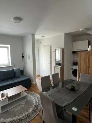 a living room with a blue couch and a table at Apartmaji MAS 3 in Ljubljana