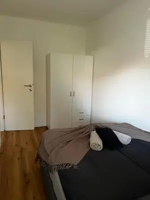 a bedroom with a bed and a white cabinet at Apartmaji MAS 3 in Ljubljana