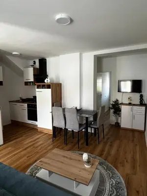 a living room and kitchen with a table and chairs at Apartmaji MAS 3 in Ljubljana