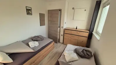 a bedroom with two beds and a dresser and a window at Hiša Ispira in Moravske Toplice