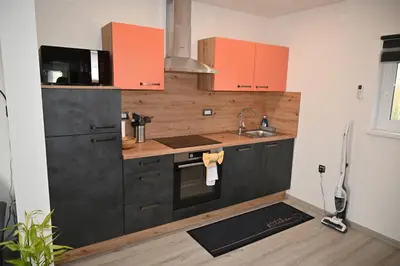 a kitchen with orange cabinets and a sink at Hiša Ispira in Moravske Toplice