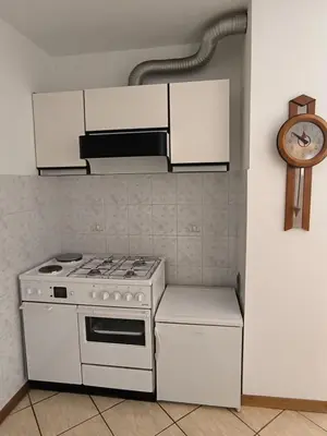 a kitchen with a white stove and a clock at Apartma Pri noni Silvi in Tolmin