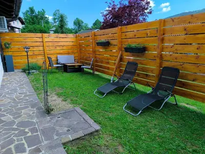 two chairs and a table in front of a fence at Apartma Pri noni Silvi in Tolmin