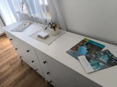 a white dresser with two books on top of it at Apartma Pri noni Silvi in Tolmin