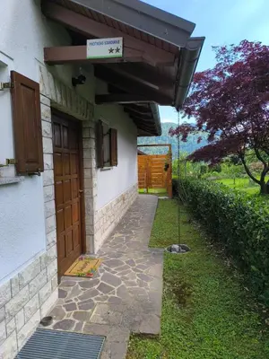 a house with a wooden door and a walkway at Apartma Pri noni Silvi in Tolmin