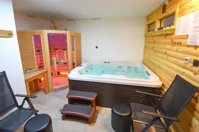 a jacuzzi tub in a room with chairs at Luxury Log House in Globoko