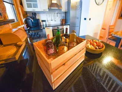 a wooden box filled with bottles on a kitchen counter at Luxury Log House in Globoko