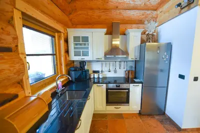 a kitchen with a sink and a refrigerator at Luxury Log House in Globoko