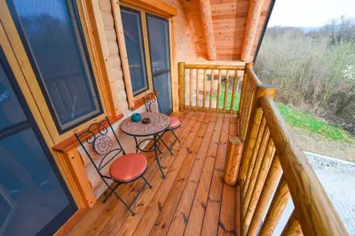a porch of a cabin with a table and chairs at Luxury Log House in Globoko