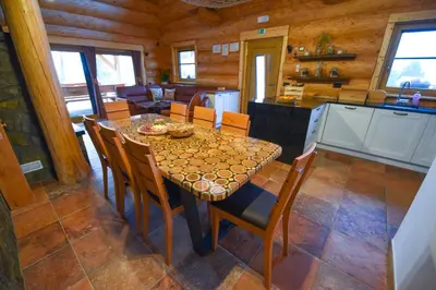 a kitchen and dining room with a table and chairs at Luxury Log House in Globoko