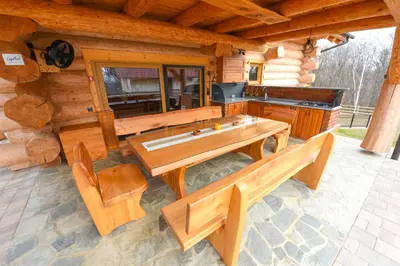a dining table and benches in front of a log cabin at Luxury Log House in Globoko