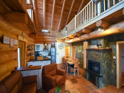 a living room with a staircase and a living room with a fireplace at Luxury Log House in Globoko