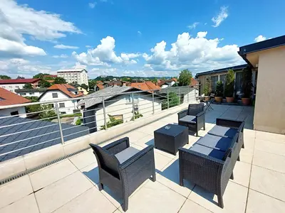 a patio with chairs and tables on a roof at GFS way studios - greenline accomodation in Ljubljana