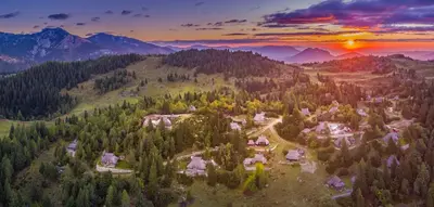 an aerial view of a village in the mountains at sunset at Chalet Pehta Velika Planina in Stahovica