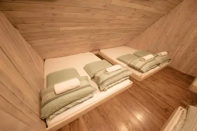 two beds in a small room with wooden floors at Chalet Pehta Velika Planina in Stahovica