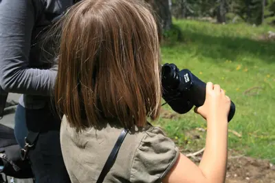 a woman is taking a picture with a camera at Chalet Pehta Velika Planina in Stahovica
