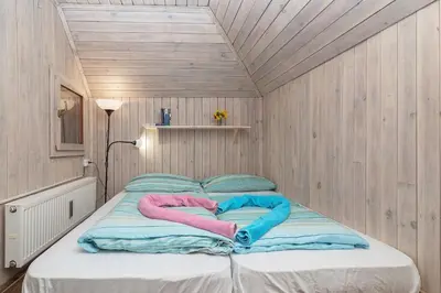 a bed in a room with two blankets on it at Chalet Pehta Velika Planina in Stahovica