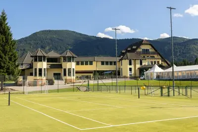 a tennis court in front of a building at Linasi Resort Slovenia in Nazarje