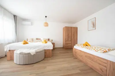 two beds in a room with wooden floors at Linasi Resort Slovenia in Nazarje