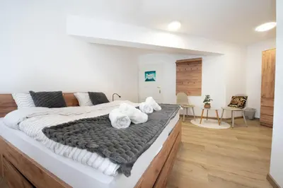 a bedroom with a large bed with towels on it at Linasi Resort Slovenia in Nazarje