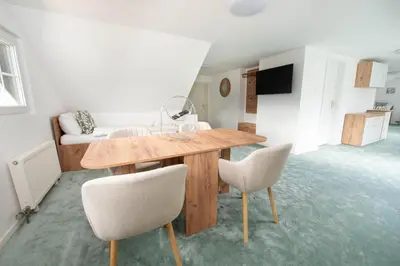 a living room with a wooden table and two chairs at Linasi Resort Slovenia in Nazarje