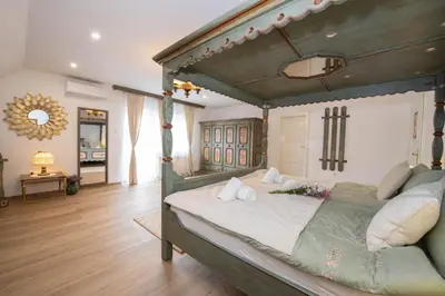 a bedroom with a large bed with a wooden canopy at Linasi Resort Slovenia in Nazarje