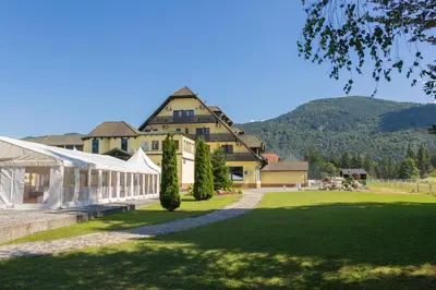 a large building with a tent in front of a lawn at Linasi Resort Slovenia in Nazarje