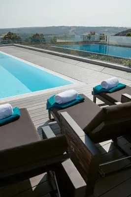 a pool with two lounge chairs and a swimming pool at Carolina Luxury Stay in Rogašovci