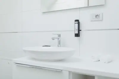 a white bathroom with a sink and a counter at Carolina Luxury Stay in Rogašovci