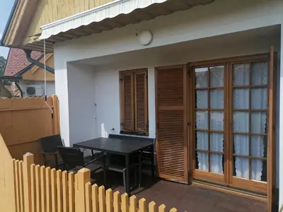 a patio with a table and chairs on a house at Apartments Prekmurska vas - Vital Resort in Moravske Toplice