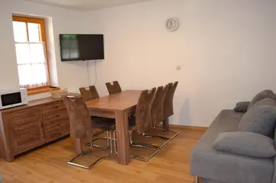 a living room with a wooden table and chairs at Apartments Prekmurska vas - Vital Resort in Moravske Toplice