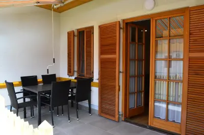 a dining room with wooden doors and a table and chairs at Apartments Prekmurska vas - Vital Resort in Moravske Toplice