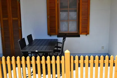 a black table and chairs next to a fence at Apartments Prekmurska vas - Vital Resort in Moravske Toplice