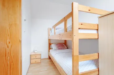 a bedroom with a bunk bed with a ladder at Apartments Prekmurska vas - Vital Resort in Moravske Toplice
