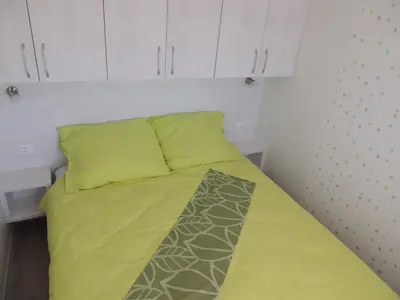 a bed with a yellow blanket and white cabinets at Saxida Wine Estate in Zalošče