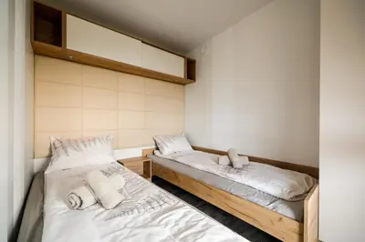 two beds in a room with white sheets at Saxida Wine Estate in Zalošče