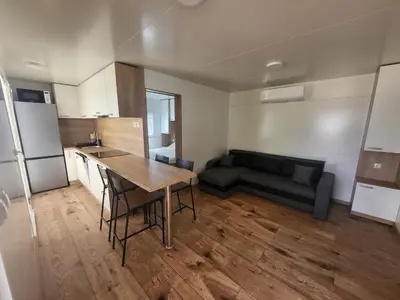 a kitchen and living room with a table and a couch at Pavel Cottage with 2 Thermal Riviera Tickets in Moravske Toplice