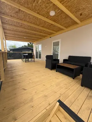 a living room with black furniture and a wooden floor at Pavel Cottage with 2 Thermal Riviera Tickets in Moravske Toplice