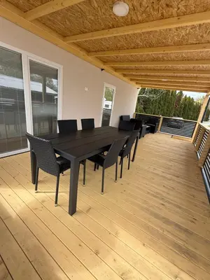a black dining table and chairs on a deck at Pavel Cottage with 2 Thermal Riviera Tickets in Moravske Toplice