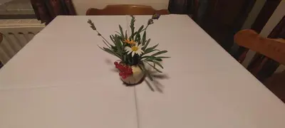 a white table with a vase of flowers on it at Turisticna Kmetija Psnak in Mojstrana