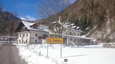 a yellow sign in the snow next to a building at Turisticna Kmetija Psnak in Mojstrana