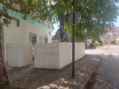 a street sign in front of a white fence at Apartments Abc Ljubljana in Ljubljana