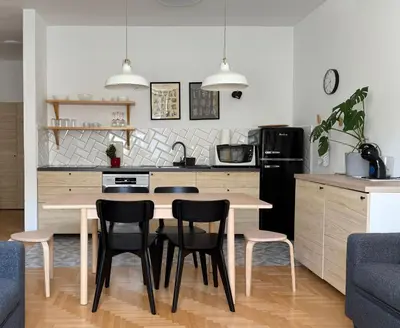 a kitchen with a table and chairs in a kitchen at Aumetz Square Apartment 2 in Idrija