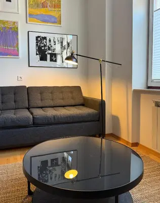 a living room with a couch and a glass coffee table at Aumetz Square Apartment 2 in Idrija