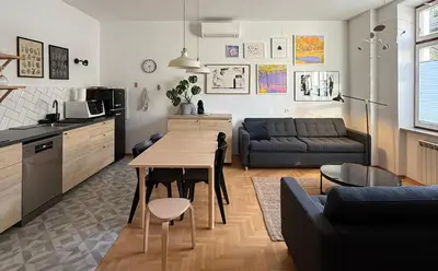 a kitchen and living room with a table and a couch at Aumetz Square Apartment 2 in Idrija