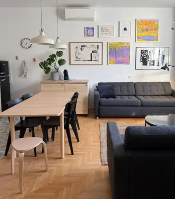 a living room with a table and a couch at Aumetz Square Apartment 2 in Idrija