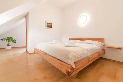 a bedroom with a wooden bed in a room at Trubarjeva 12 - The view in Ljubljana