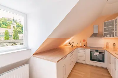 a kitchen with white cabinets and a window at Trubarjeva 12 - The view in Ljubljana