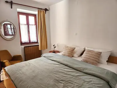 a bedroom with a large bed and a mirror at Apartmaji Boka in Bovec